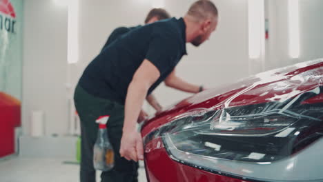car film installation. applying foil on car in salon