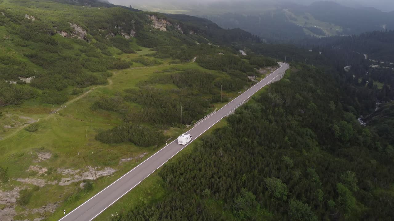 4K drone footage captures Swiss Alps' natural beauty as the sun sets through clouds at Gotthard Pass
