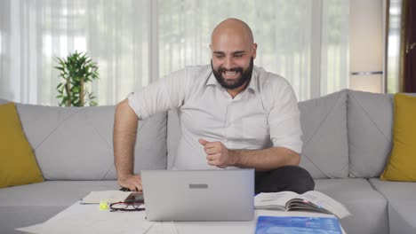 el hombre de la oficina se alegra de lo que ve en la computadora portátil.