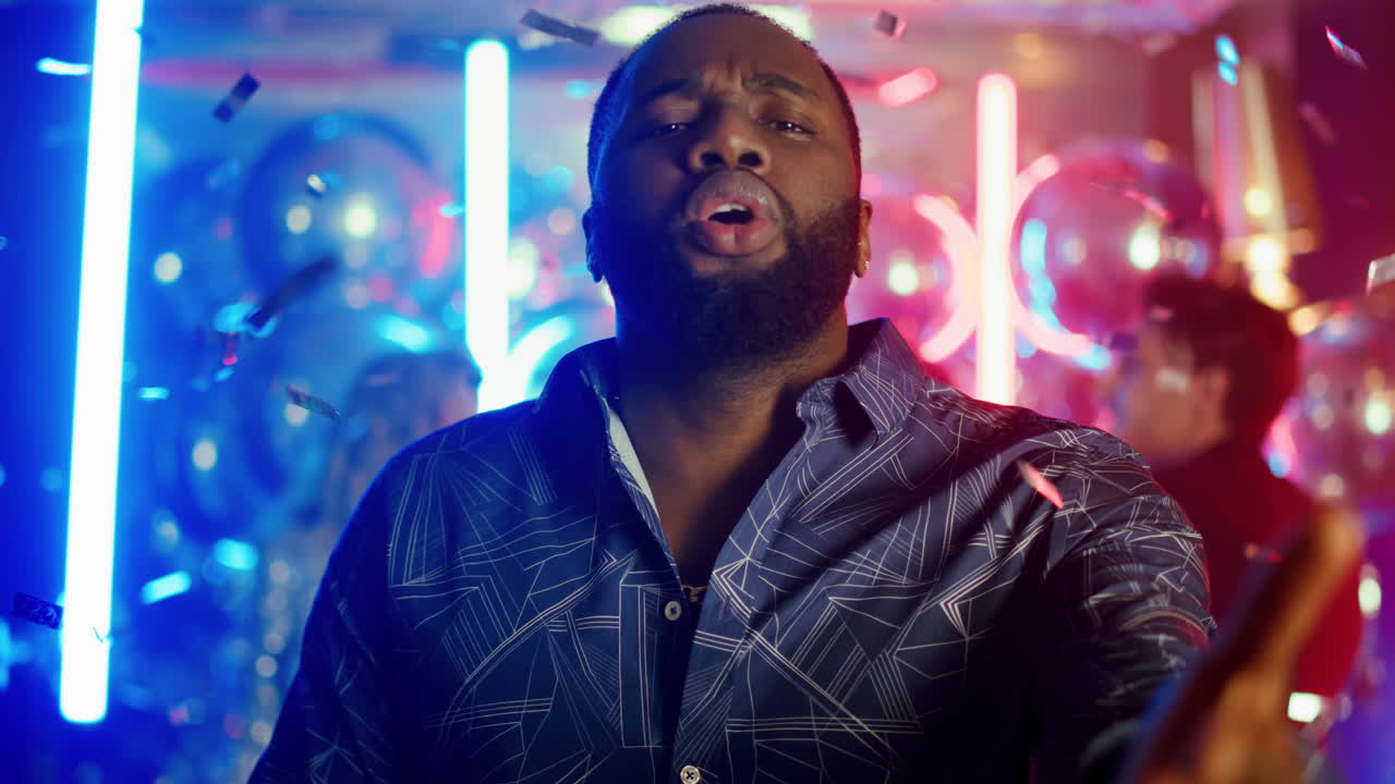 Lovely african man clapping hands at party. Afro guy spending time in club