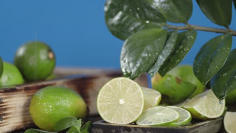 limas frescas con hojas bajo las gotas de agua.