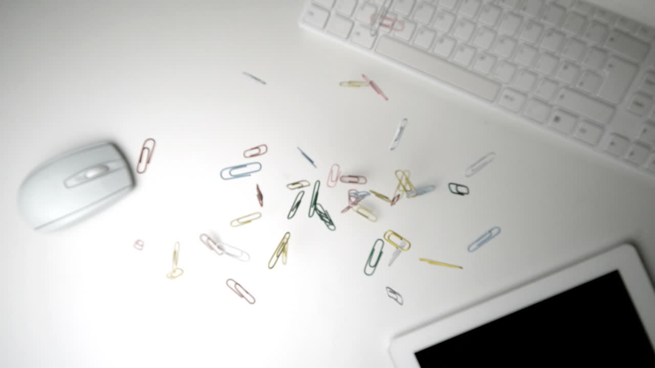 Paperclips falling over keyboard mouse and tablet pc