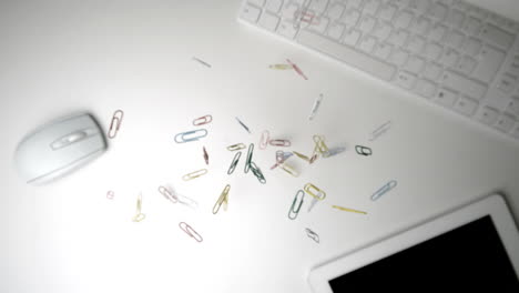 clips que caen sobre el teclado, el ratón y la tableta