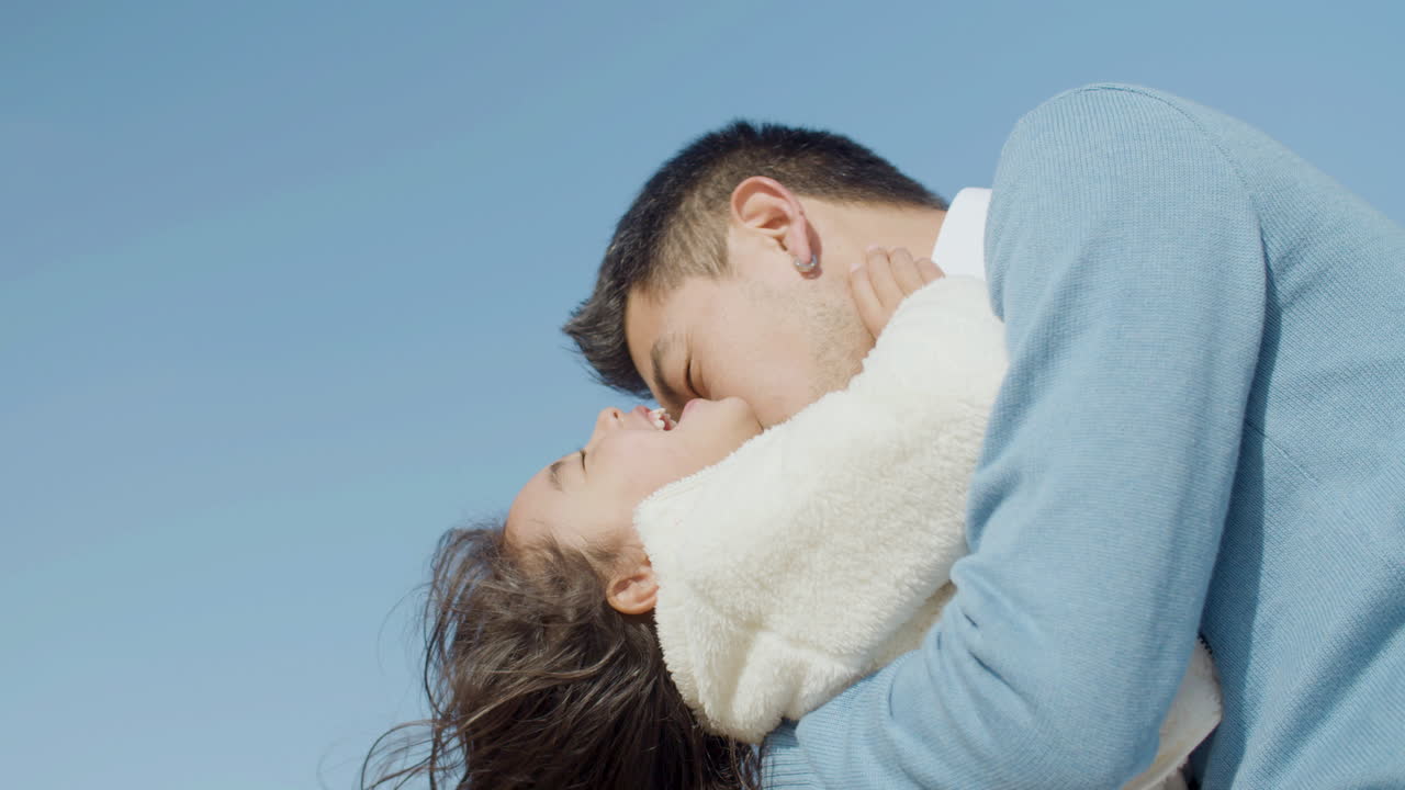 행복한 어린 딸을 팔에 안고 해변에서 놀고 있는 일본 남자