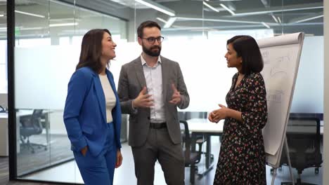 a collaborative business discussion: three professionals engaging in a dynamic conversation in a modern office setting