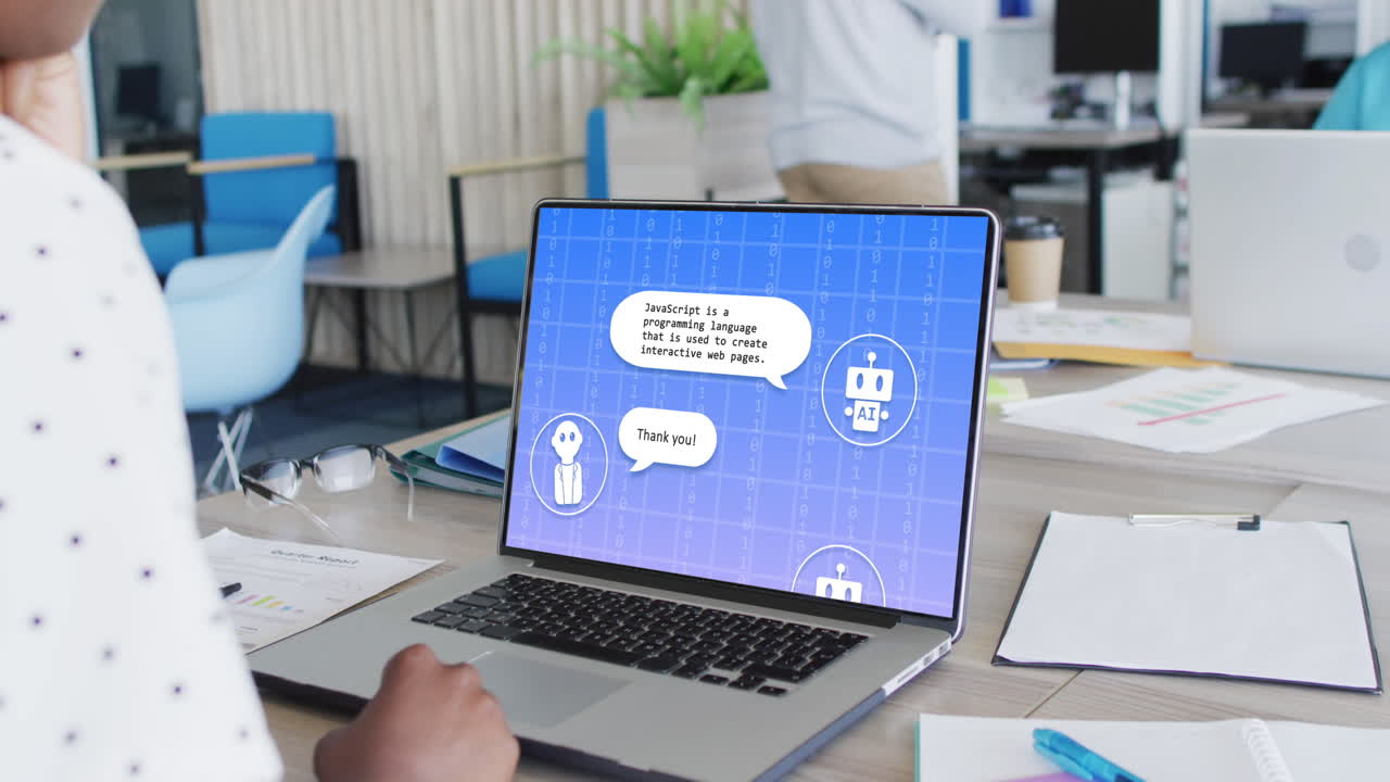 Donna d'affari birazziale in ufficio che usa il computer con chat di messaggistica digitale AI sullo schermo.