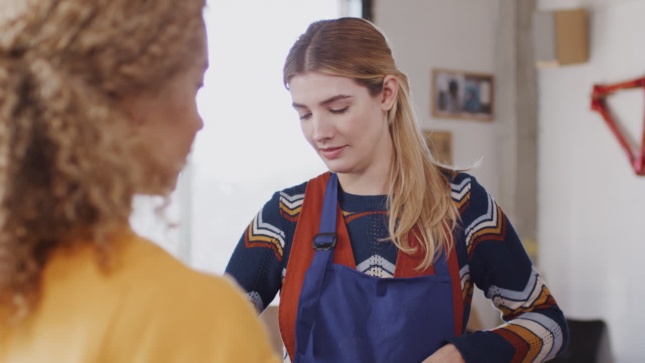 Team Of Female Workers In Workshop Assembling Hand Built Sustainable Bamboo Bicycle Frame