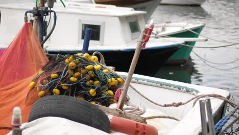 barco de pesca con redes y flotadores en el muelle