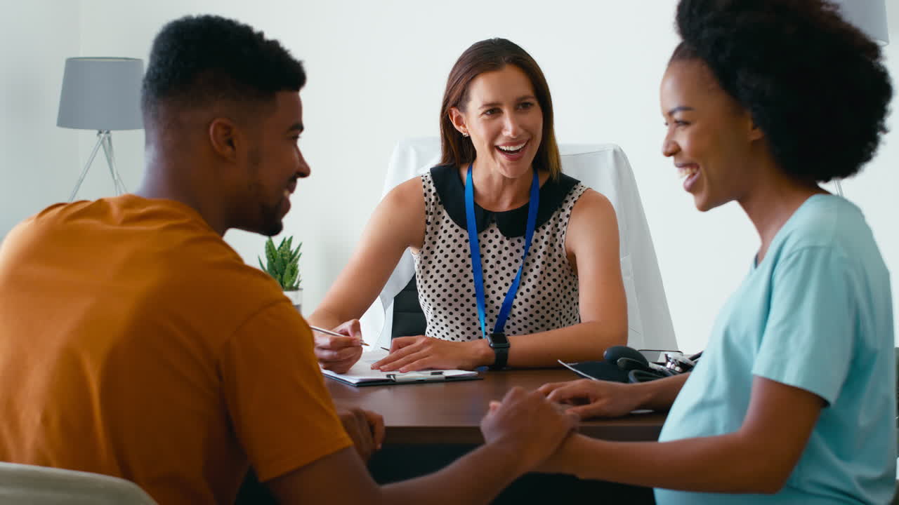 pareja embarazada en una cita con una mujer médico o médico de cabecera en la oficina