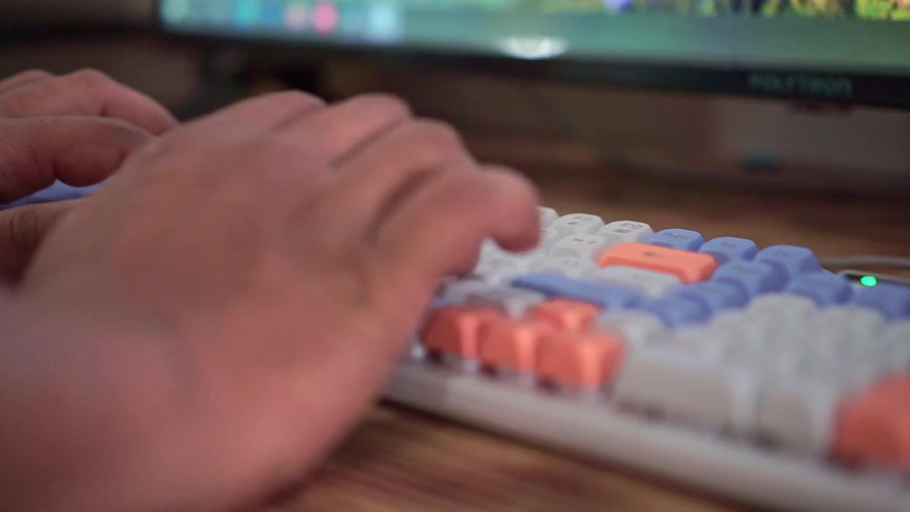Person typing on colorful mechanical keyboard, computer work and digital technology concept.