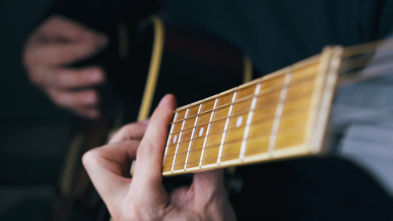experienced artist plays acoustic guitar using barre chords
