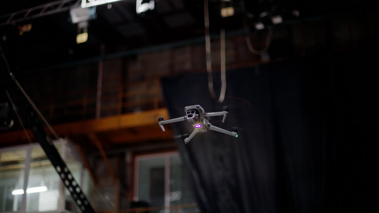 Drone flying and filming near flashing studio lights and camera equipment on a TV set