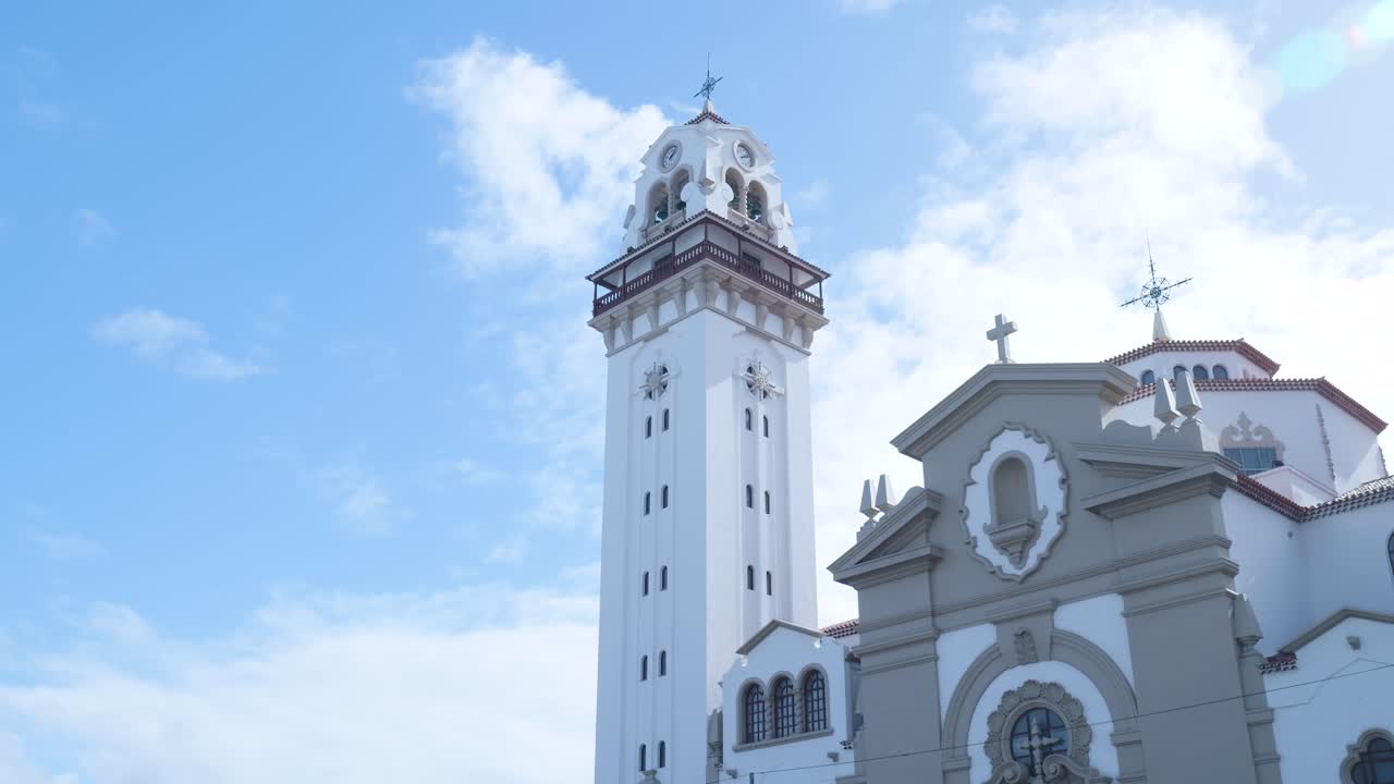 Campanile di chiesa bianco su cielo blu con nuvole