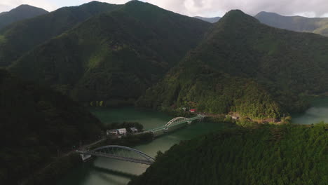 Vista-Aérea-Del-Puente-Miyama-Y-Mito-Sobre-El-Lago-Okutama-Con-Exuberantes-Montañas-Verdes-En-Okutama,-Tokio,-Japón