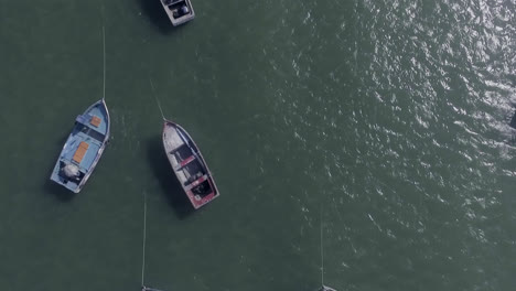 aerial drone shot of some small colored boats floating on the sea on a beach north of lima, peru