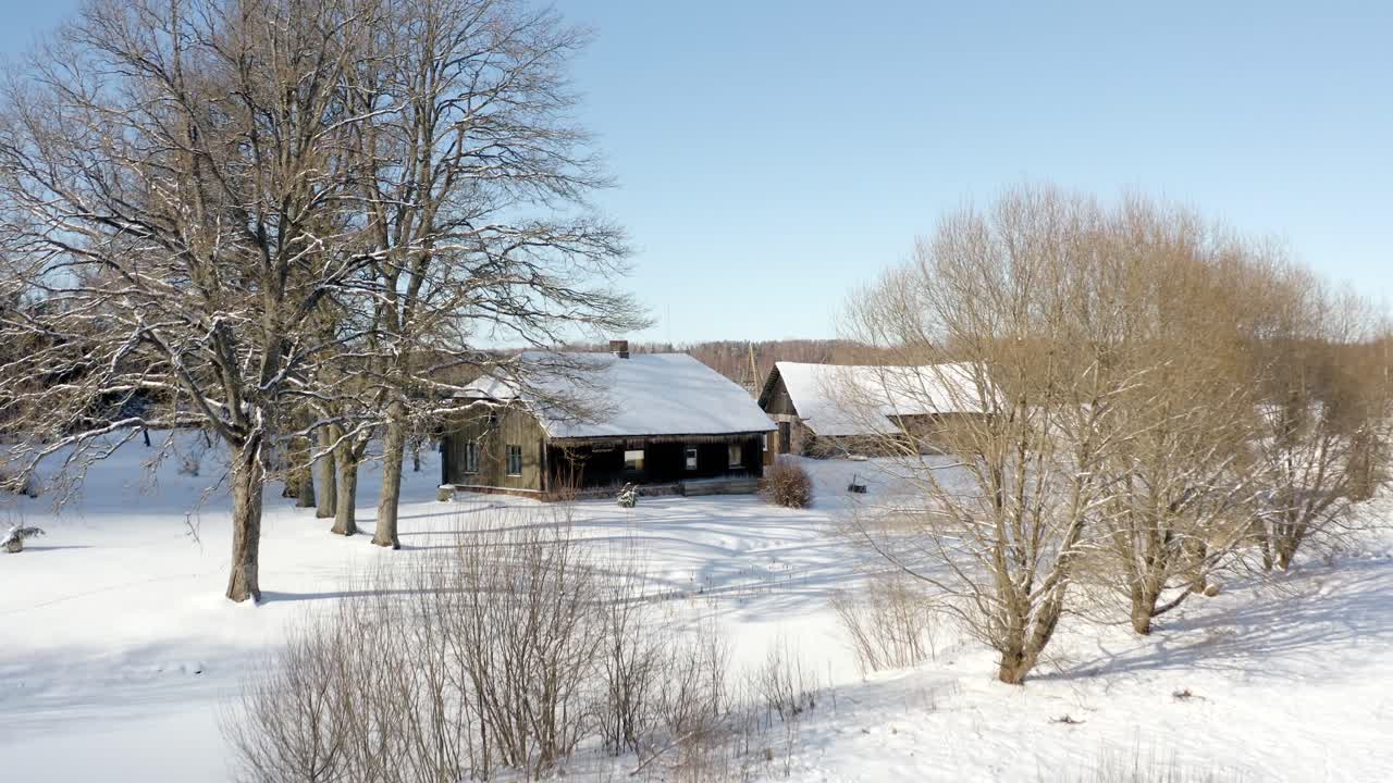 Historic old wooden family house surrounded by large trees in countryside on a sunny day in winter scenery. Travelling in Europe.