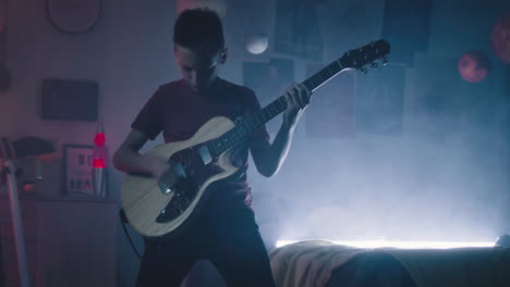 teenager playing guitar in a colorful room