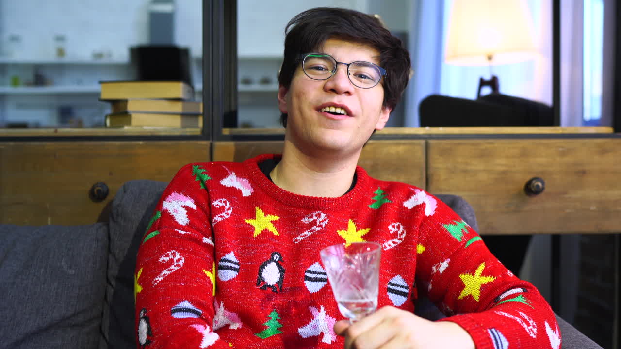 hombre en suéter de navidad con vaso de vino