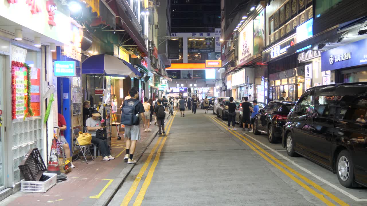 Busy city night, where streets gleam bright, vendors sell under neon lights