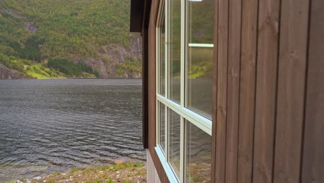 camera sliding along wall of hydroelectric powerplant markaani in norway before revealing warning sign telling about powerplant - bolstadfjord sea in background