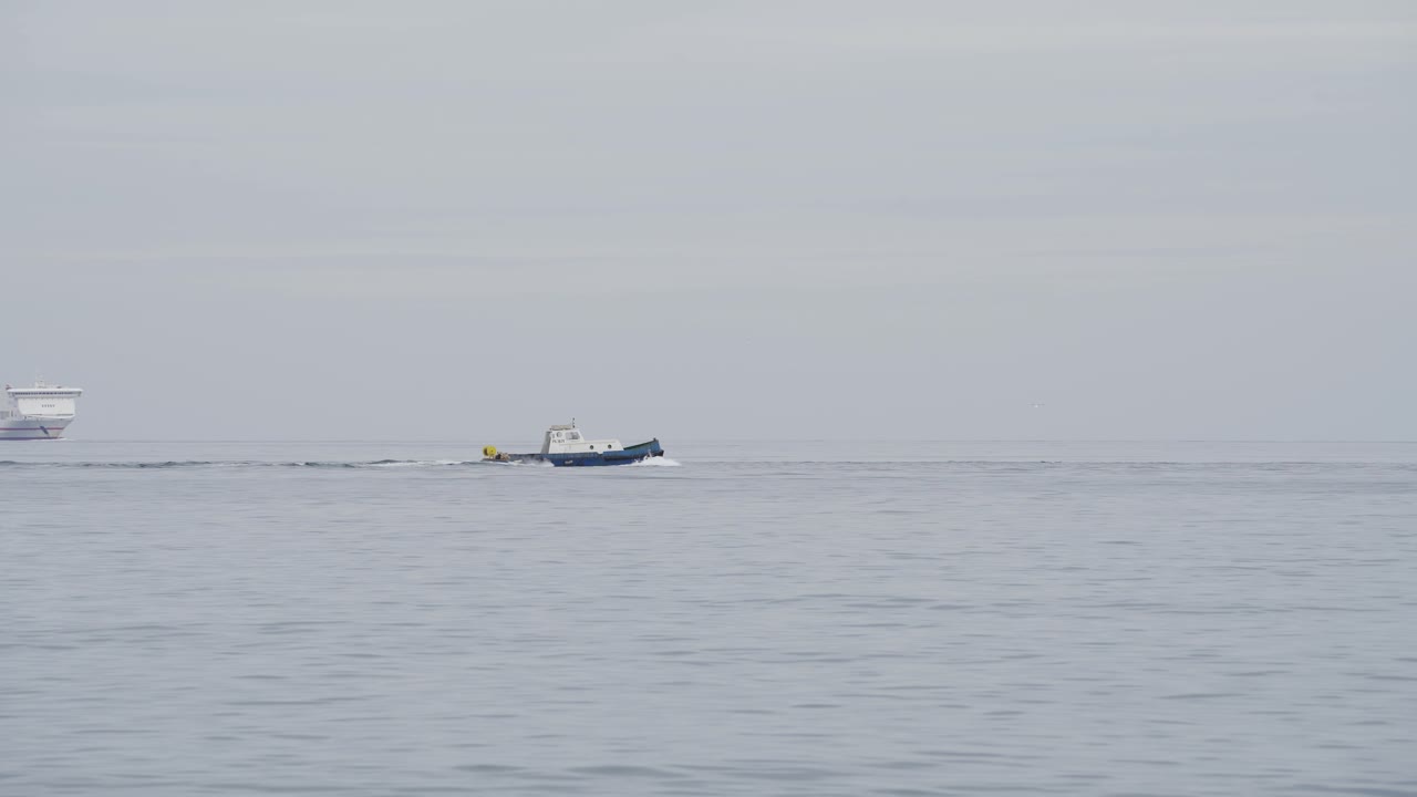 큰 여객선 앞에 작은 어선이 출항