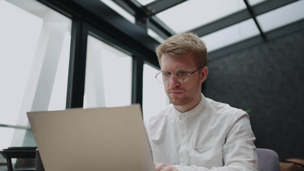 focused male using internet banking service writing email searching information on laptop