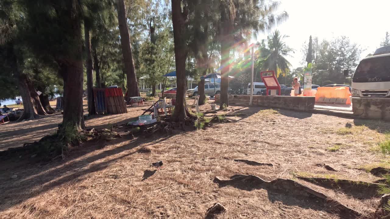 un camión se mueve a través de un parque soleado y lleno de árboles.