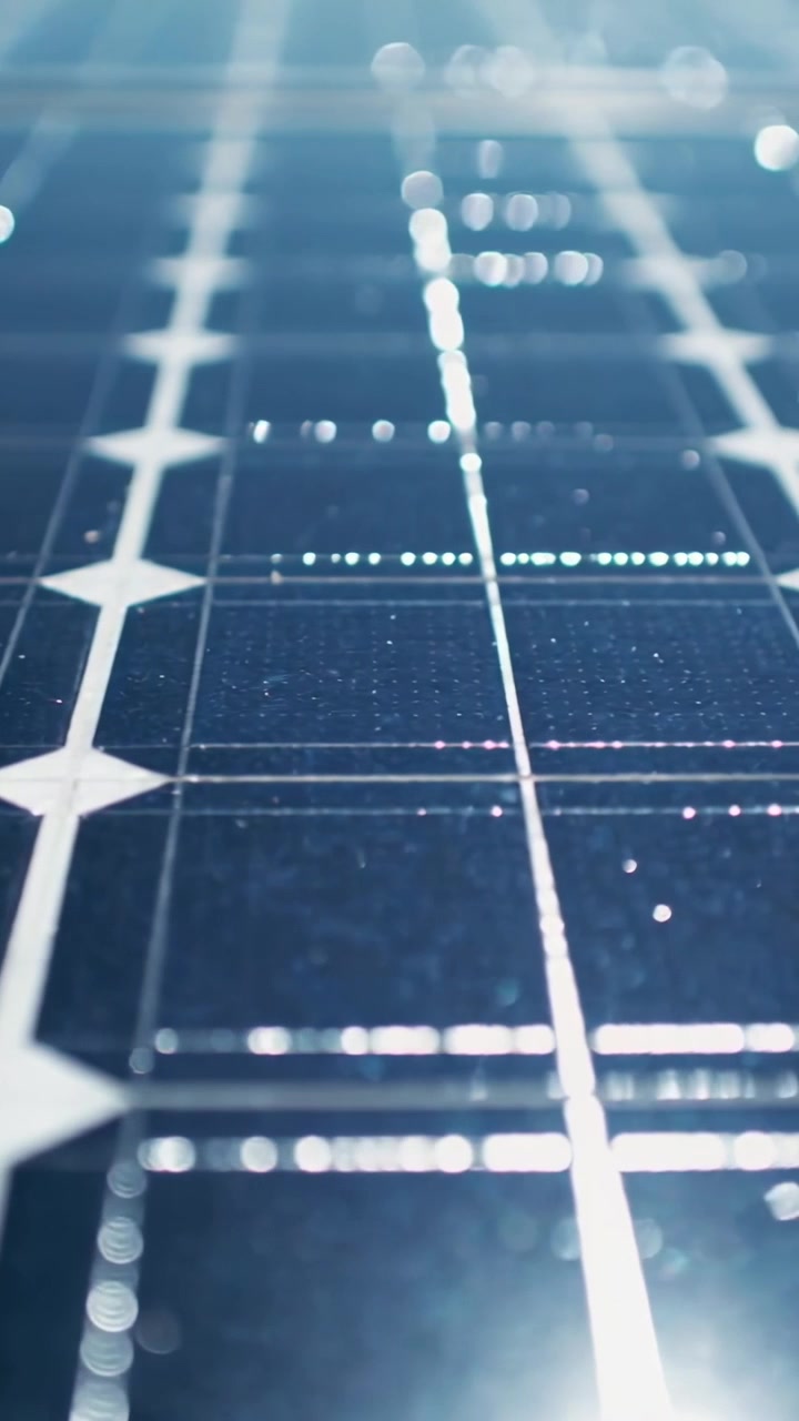 Video verticale: La luce del sole che fa scivolare l'obiettivo su un pannello di un array, mostrando nodi a diamante e polvere.
