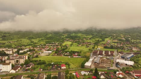 explore una cautivadora vista de un avión no tripulado de un paisaje urbano bullicioso bajo una lluvia de verano, con calles relucientes y un clima dinámico que mejora el encanto urbano