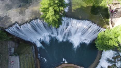 aerial rising over huge waterfall pliva in jajce, bosnia and herzegovina