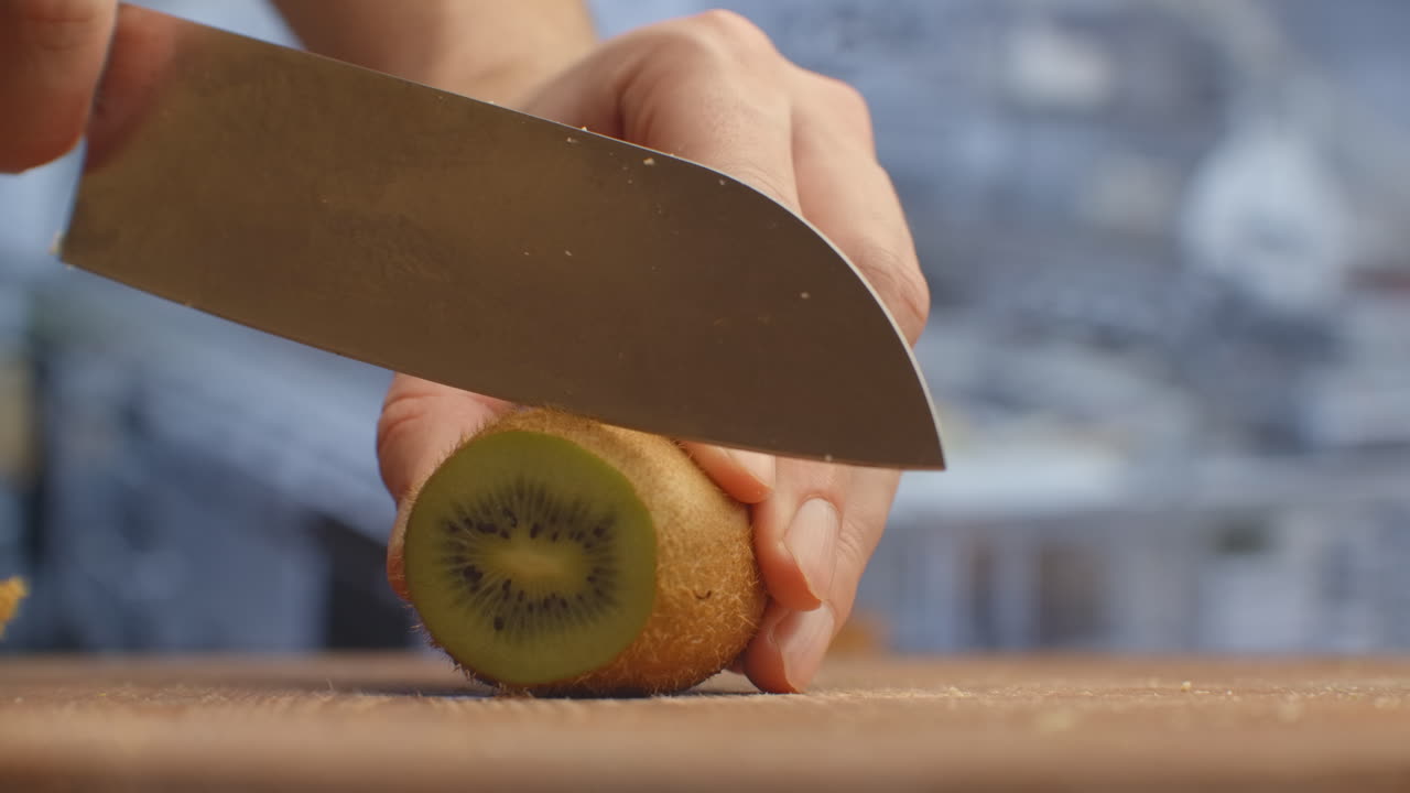Cut with a knife on a wooden board closeup kiwi in the kitchen. shred
