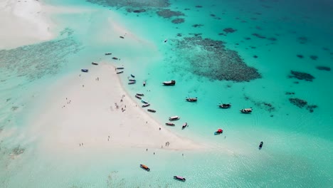 snorkeling tour boats in mnemba island atoll near zanzibar,tanzania africa coral reef, aerial pan right shot