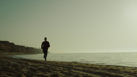 atletas corriendo al aire libre al amanecer. mujer corriendo en la playa con ropa deportiva.