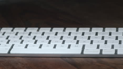 white keyboard on wood table in dark room, slow parallax