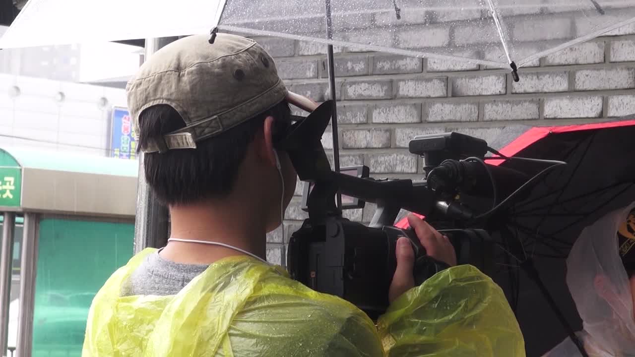 TV News cameraman interviewing a man in Sokcho, South Korea