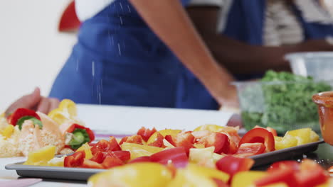 cerca de la sal que se salpica en la bandeja de pimientos en la clase de cocina de la cocina