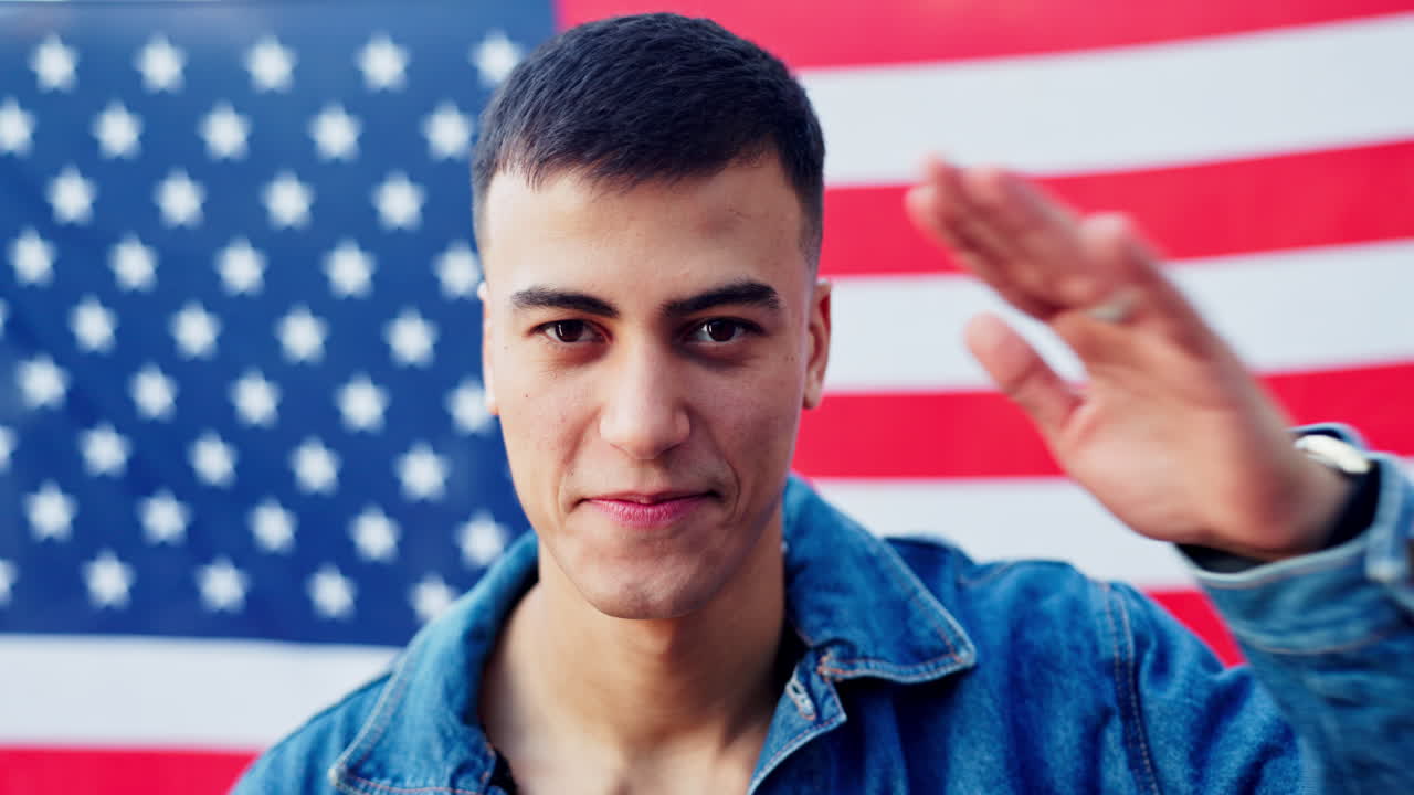 Young man smiling in front of an American flag