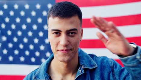 young man smiling in front of an american flag