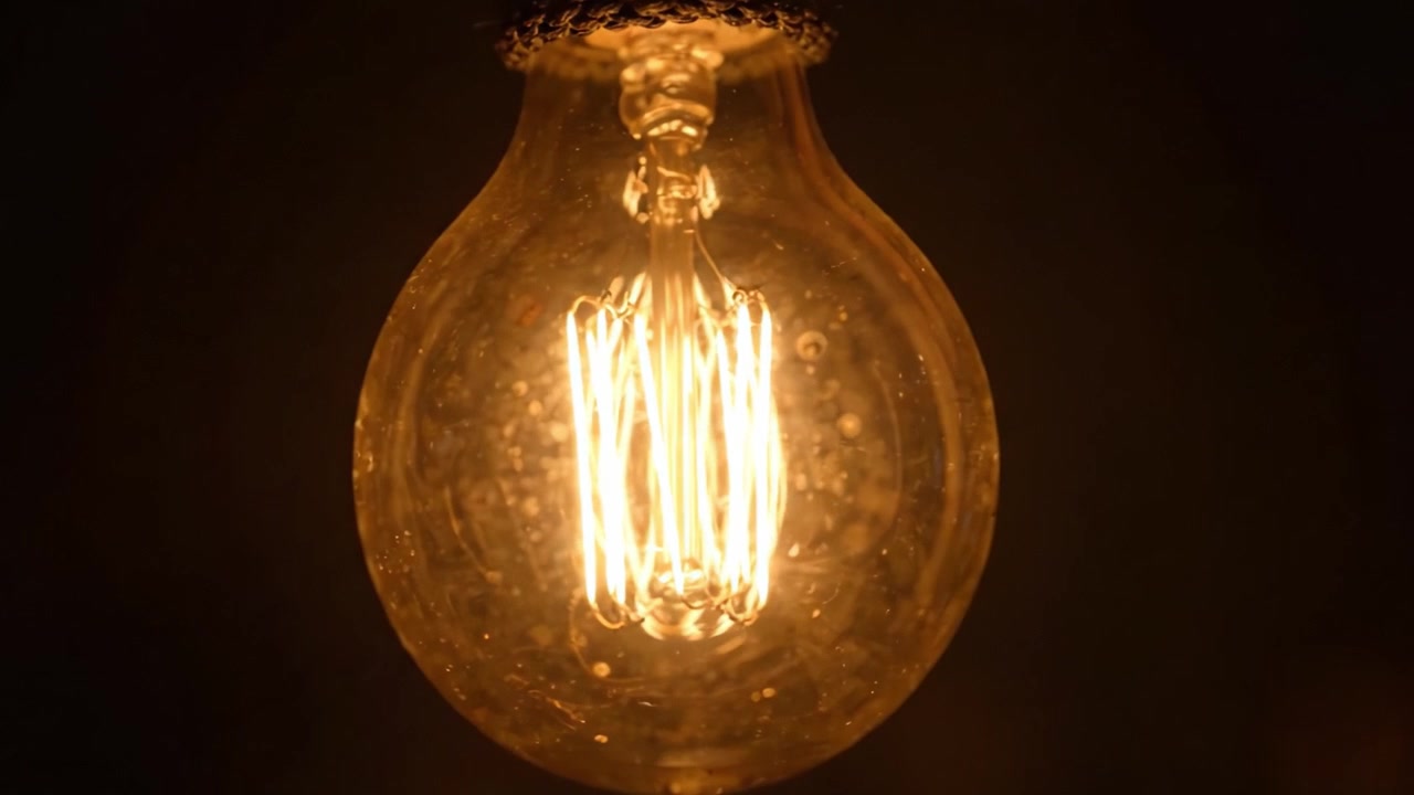 Uno sguardo accattivante a una lampadina vintage: Un bagliore caldo che illumina l'oscurità con eleganza senza tempo e un'atmosfera soffusa in penombra