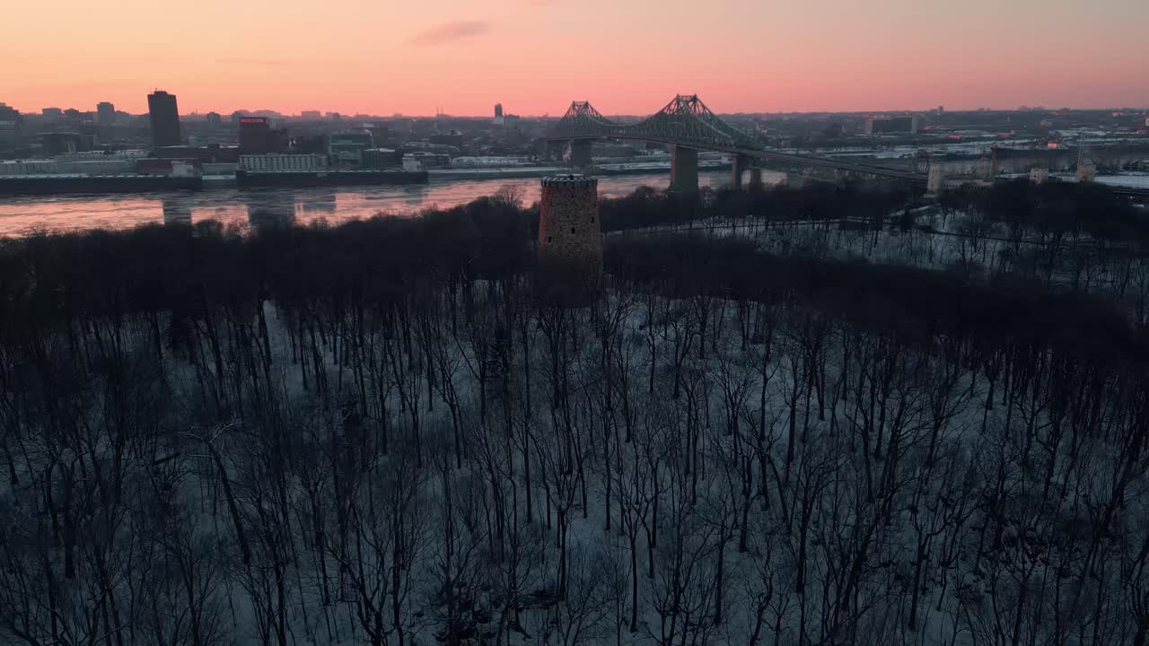 fotografía aérea sobre el parque jean drapeau en montreal coty revelando el puente jacques cartier y el horizonte con la torre lewis en primer plano al atardecer, provincia de quebec, canadá