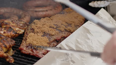 las costillas de cerdo a la parrilla con glaseado de azúcar marrón se colocan en papel de aluminio y se envuelven para cocinar