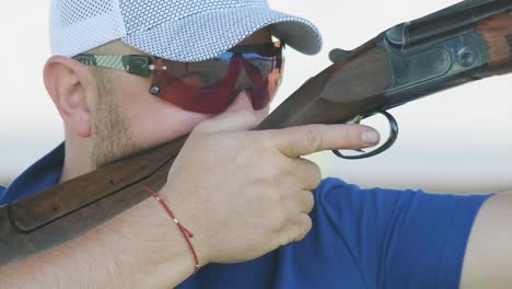 sportsman shoots from a double-barreled shotgun, a sports field for a shooting test is shooting at flying skeet