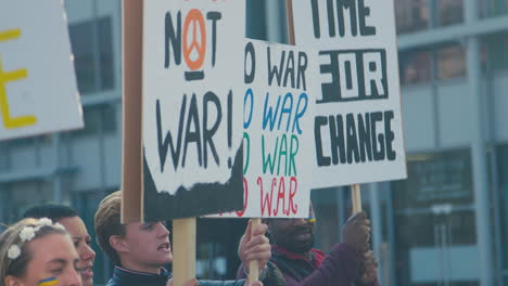 grupa protestujących z plakatami na ukraińskim marszu antywojennym