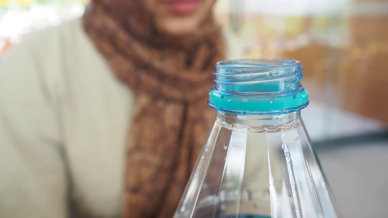 persona que abre una botella de agua