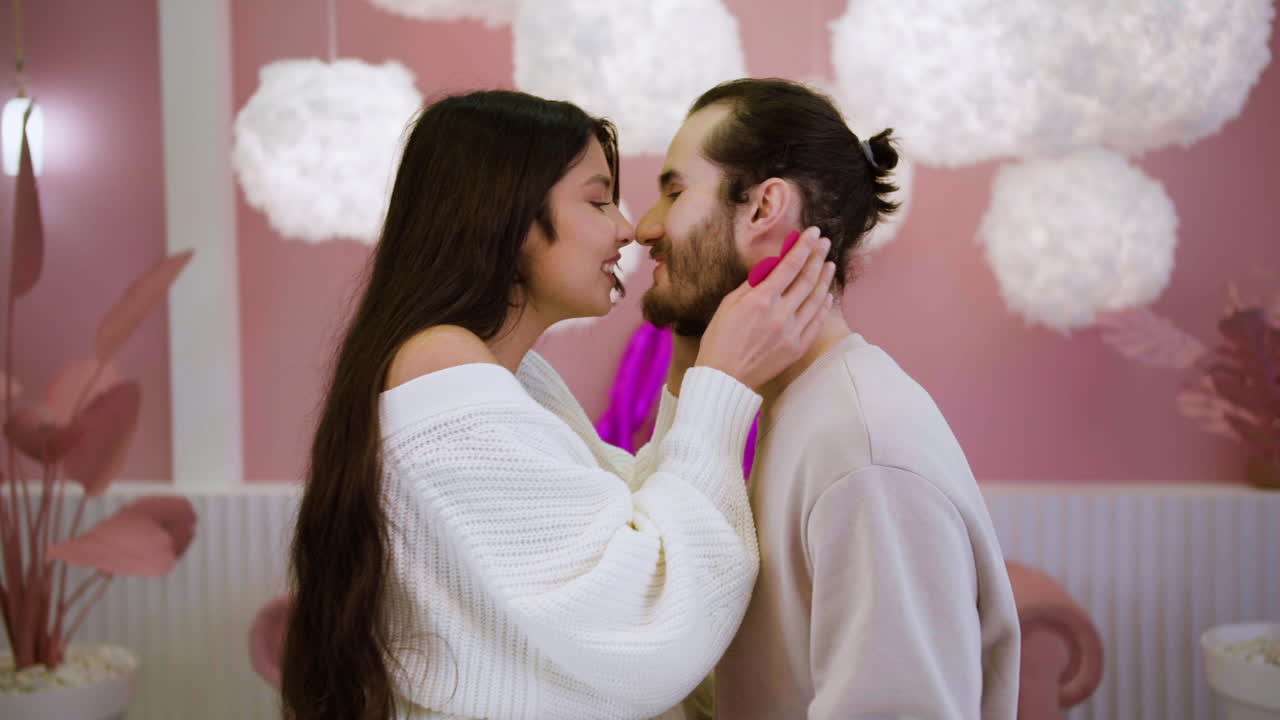 um casal a beijar-se em casa.