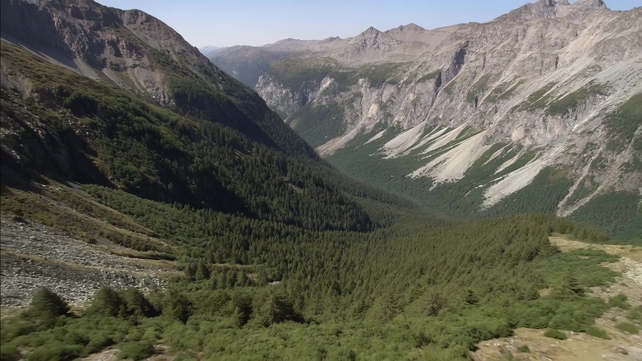 Bjerglandskab, ingen observeret handling, statisk scene, i en højtliggende bjergkæde med dale og grønne områder, med bjerge, dale, grøn vegetation, set fra et fugleperspektiv