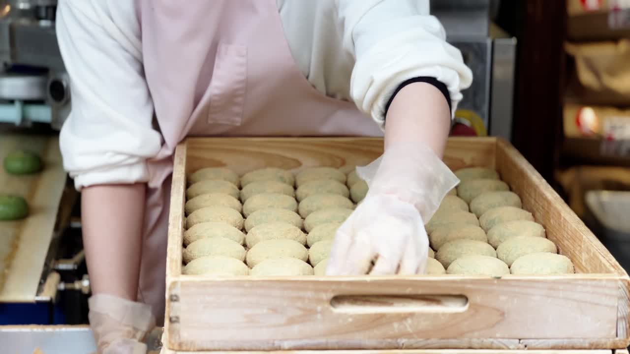 Ręce w skrobi przygotowujące kleisty japoński deser ryżowy mochi w fabryce