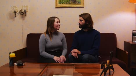 couple sitting on sofa in retro living room