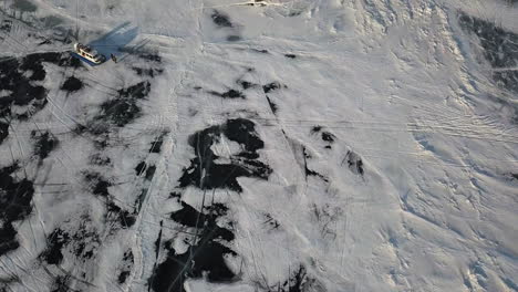 frozen lake aerial view with boat and people