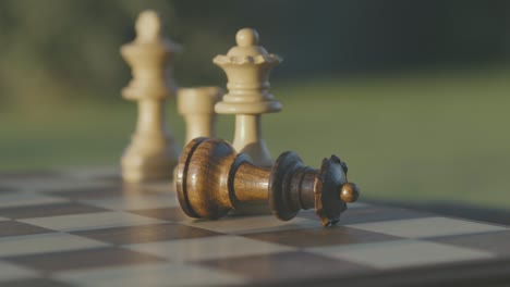 在露天桌子上放置的木制国际象棋板上的棋子细节